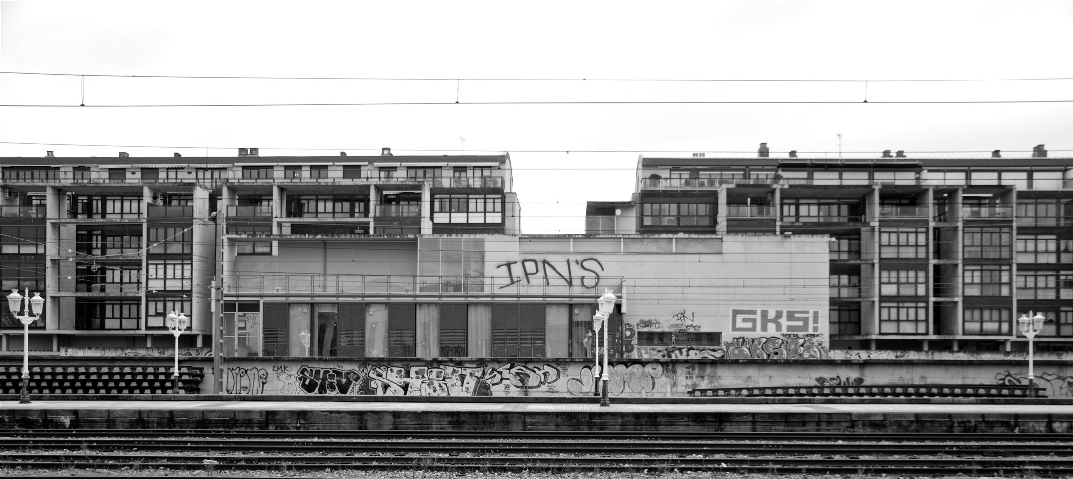 Gasteizko tren-geltokia eta atzean etxebizitzak, zuri-beltzean.